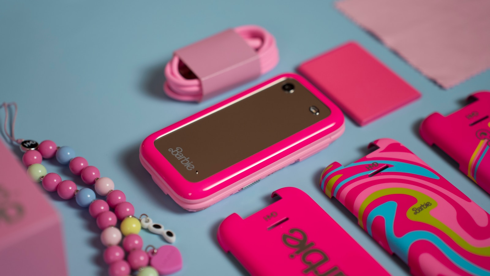 A pink cell phone sitting on top of a blue table